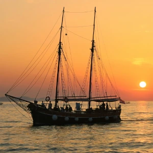 Ship over the sea and sun close to the horizon